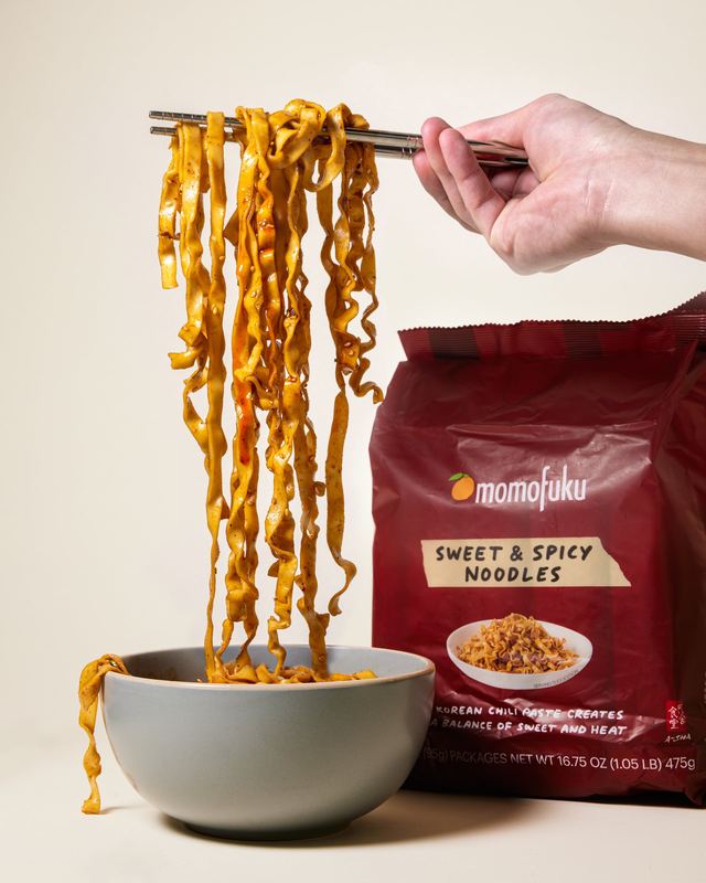 Noodles lifted from a bowl with the pack, Momofuku by David Spector