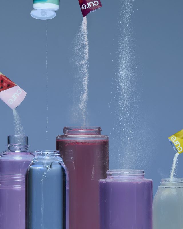 Powdered drink mix pouring into bottles, Bon Appétit by David Spector
