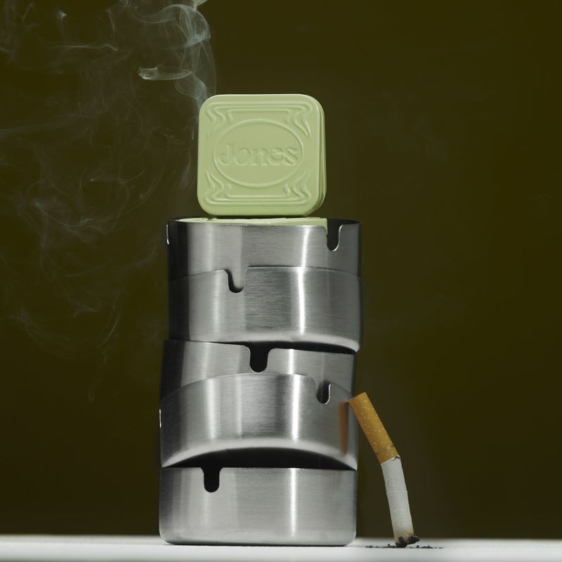 Tin on stacked ashtrays with a smoking cigarette, Byline Jones Editorial by David Spector