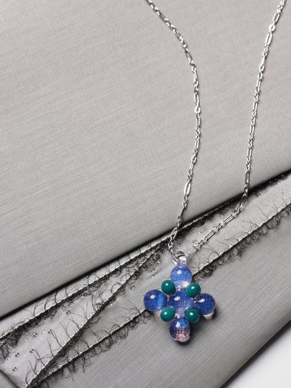 Beaded pendant on a chain over grey fabric, Keane Art Deco by David Spector