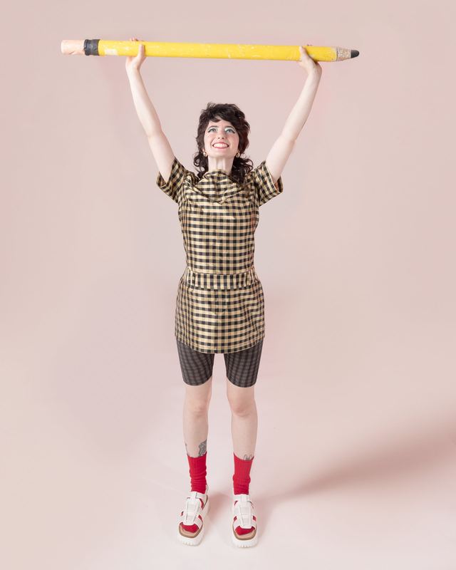 Holding a giant pencil overhead, Sarah Squirm by David Spector