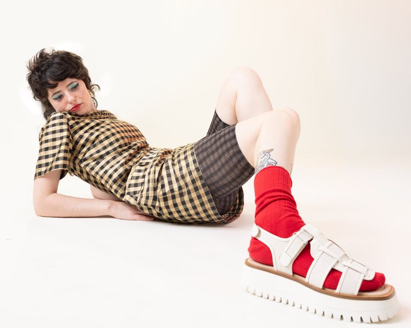 Reclining in red socks and sandals, Sarah Squirm by David Spector