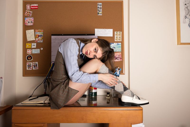 Curled up on a desk by a pinboard, Madeline Cash by David Spector