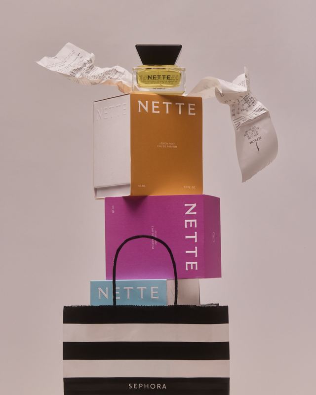 Bottle on a stack of boxes and a Sephora bag, Nette by David Spector