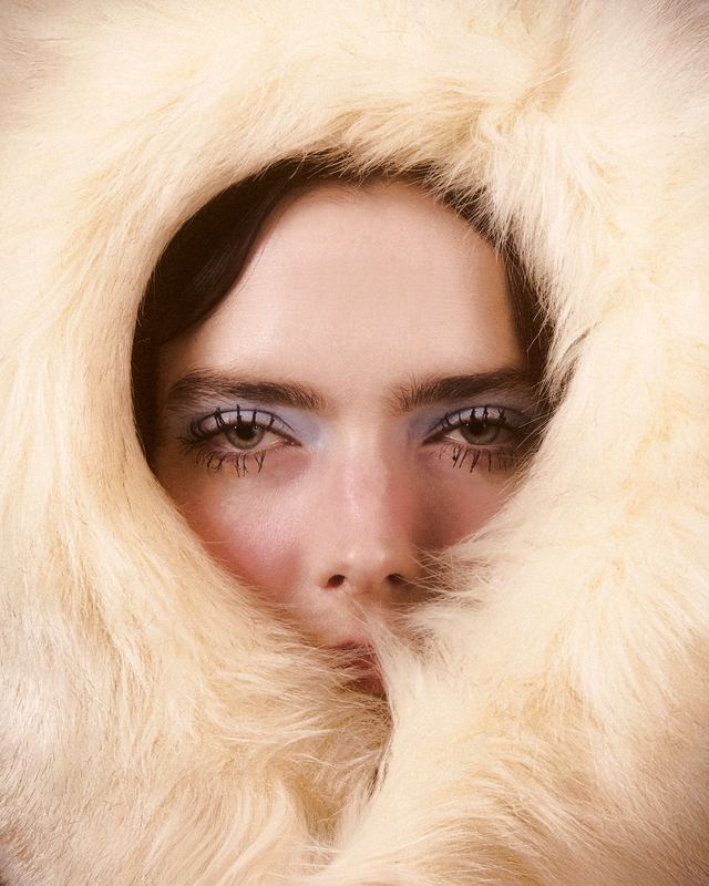 Framed by a white fur hood, Snow Editorial by David Spector